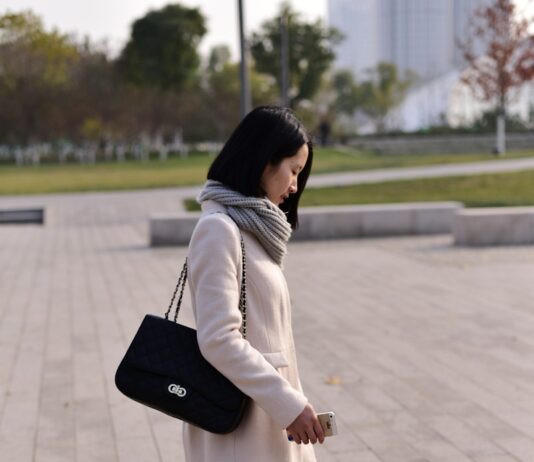 겨울철 다이어트 성공을 위한 심리적 요령 woman walking while holding smartphone